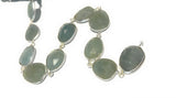 One-foot Aquamarine bezel chain arranged on a white background for jewelry making