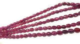 Faceted Pink Sapphire beads photographed from the side to show gemstone thickness and center-drilled construction.