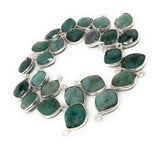 Natural emerald gemstone charms displayed on white background for premium jewelry making supplies