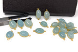 Aquamarine connector showing gemstone thickness, gold bezel and attachment loops