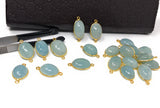 Aquamarine connector showing gemstone thickness, gold bezel and attachment loops