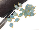Side profile of an Aquamarine connector showing gemstone thickness, gold bezel and attachment loops