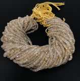 Natural Golden Rutilated Quartz beads photographed on a black surface to show their transparency and sparkle