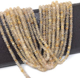 Natural Golden Rutilated Quartz beads displayed on dark surface