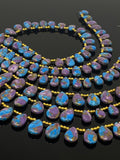 Blue and purple copper turquoise teardrop beads with polished surfaces and top-drilled holes.