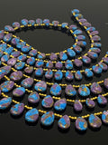Blue and purple copper turquoise teardrop beads with polished surfaces and top-drilled holes.