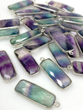 Close up of faceted fluorite briolette charms showing purple green blue natural crystal colors