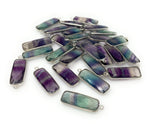 Multiple rainbow fluorite charms arranged together for bulk jewelry making supplies