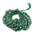 Natural genuine Emerald smooth oval bead strands displayed on white background for necklaces bracelets and jewelry making