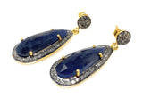 Set of blue sapphire pave diamond earrings arranged on white background, showing side shot of the earrings