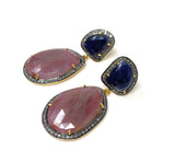 Set of blue and salmon sapphire earrings arranged on white background showing side view of the earrings