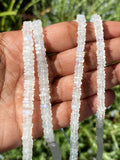 Rainbow Moonstone strand held in a hand