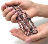 Pink opal heart chakra beads held in hand showing bead size and spiritual jewelry making supplies