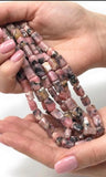 Pink opal Nugget beads held in hand showing bead size and spiritual jewelry making supplies