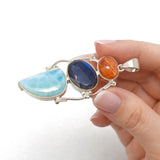 larimar labradorite sunstone pendant held in hand sideways  showing size and silver craftsmanship
