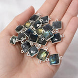 Labradorite gemstone connector held in hand showing sterling silver setting