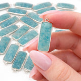 Amazonite gemstone charm held between fingers showing size scale natural gemstone jewelry making charm