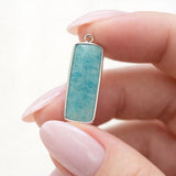 Close up of amazonite gemstone charm showing natural blue green stone pattern with silver plated setting