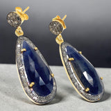 Close-up of natural blue sapphire and pave diamond earrings showing sparkle, gemstone clarity and sterling silver craftsmanship