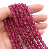 Pink sapphire beads held in hand showing bead size and natural gemstone detail