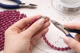 Pink sapphire gemstone beads on jewelry designer workbench with tools and wire