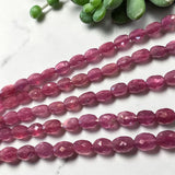 Close up of pink sapphire gemstone beads showing natural pink color and sparkle