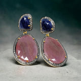 Set of blue and salmon sapphire earrings arranged on minimal background, multi sapphire luxury jewelry display