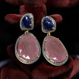Set of blue and salmon sapphire earrings arranged on dark background, multi sapphire luxury jewelry display