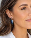 Woman wearing blue sapphire pave diamond statement earrings