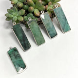 Natural Emerald pendant charm measuring approximately 31.75 by 10.5 millimeters