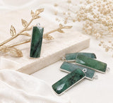 Faceted rectangular green Emerald charm in a double-sided sterling silver bezel with a top loop