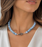 Blue Larimar necklace for spiritual jewelry and throat chakra healing shown on Woman's neck.