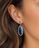 Woman wearing blue sapphire pave diamond statement earrings
