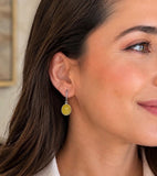 Woman wearing yellow sapphire dangle earrings with grayish black rhodium and diamond details