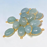 Close-up of natural Aquamarine connectors showing pale blue color variations and smooth polished surfaces