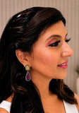 Woman wearing ruby and yellow sapphire statement earrings to demonstrate their scale on the ear