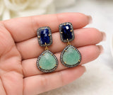 Natural emerald & blue sapphire statement earrings with genuine pavé diamonds shown on a hand for size reference.
