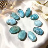Ten natural Larimar freeform cabochons with blue and white patterns arranged as one gemstone lot