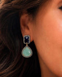 Natural emerald & blue sapphire sterling silver dangle earrings with genuine pavé diamonds worn by a model.