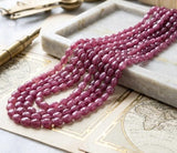 AAA Pink Sapphire gemstone beads showing organic oval shapes and sparkling faceted surfaces