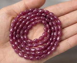Pink Sapphire gemstone strand displayed in a hand