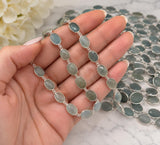 Aquamarine chain held in a hand to demonstrate gemstone size and scale