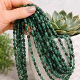 Premium natural emerald oval beads showcasing smooth polished finish and beautiful green gemstone color.