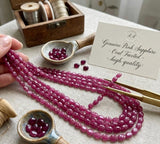 Natural Pink Sapphire oval beads photographed  to show faceting, texture and transparency.