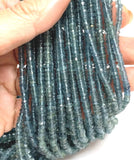 Hand holding natural Blue Tourmaline gemstone bead strand showing bead size, color, and sparkle.