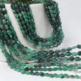 Oval Emerald gemstone beads arranged to display natural beauty, color consistency, and craftsmanship.