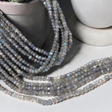 Shimmer coated Labradorite bead strands arranged for handmade jewelry projects