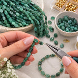 Natural Emerald oval gemstone beads being used with jewelry making tools to create handmade gemstone jewelry