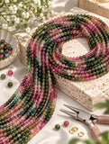 Watermelon Tourmaline round gemstone bead strands arranged in a jewelry making display with natural multicolor beads