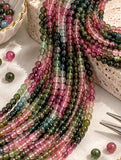 Close-up of natural Watermelon Tourmaline round bead strands showing polished pink green and blue green gemstone colors